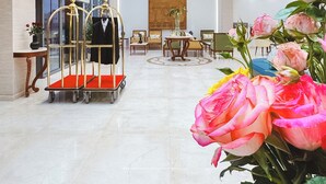 Eine geräumige Lobby mit hoher Decke, großen Fenstern und einer zentral gelegenen Sitzecke.