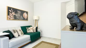 Un salon moderne avec un canapé vert, une lampe et une sculpture décorative.