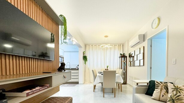 A modern living room with a TV, sofa, and dining area. - Res. Villa de Collina-Centro de Floripa (Florianopolis)