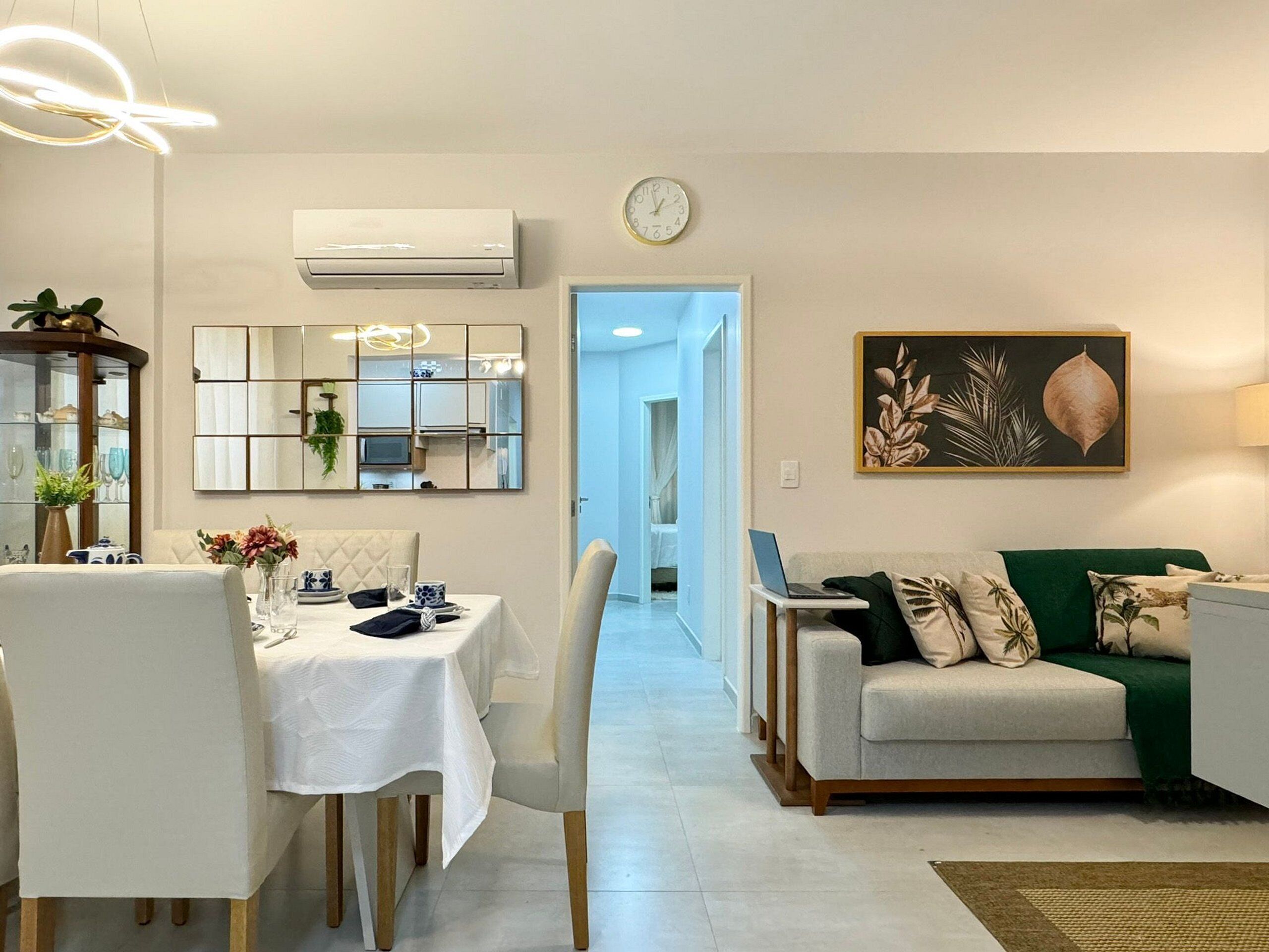 Un salon moderne comprenant un coin repas, un canapé, une table basse et un tableau accroché au mur.