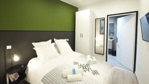 A modern hotel room with a bed, a nightstand, a wardrobe, and a bathroom visible through a door. - 06R - Nice modern apartment - Vieux Nice (Nice)