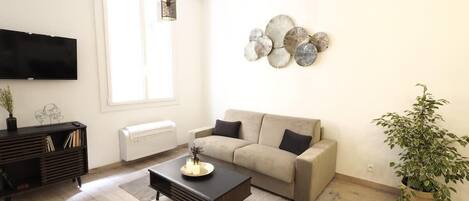 A modern living room with a sofa, coffee table, and a TV.