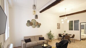 A modern living room with a sofa, coffee table, and a dining area with chairs and a table. - 06R - Nice modern apartment - Vieux Nice (Nice)