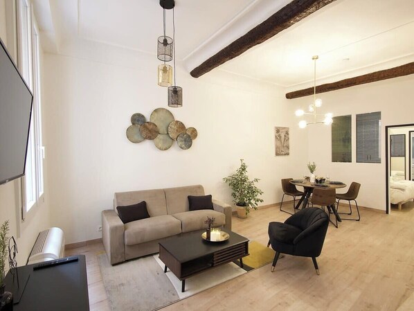Un salon moderne comprenant un canapé, une table basse et un coin repas avec des chaises et une table.