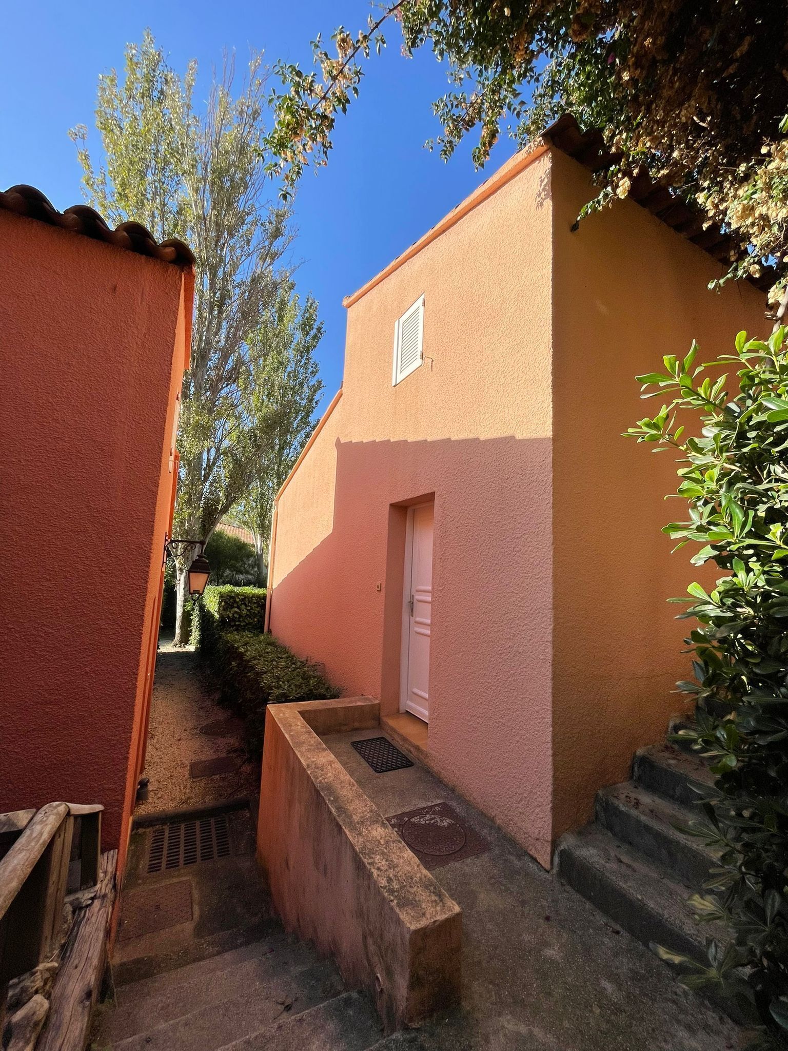 Un estrecho callejón con un edificio pequeño que tiene una puerta y una ventana.