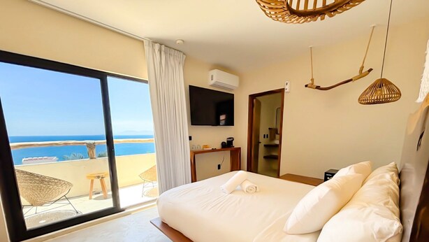 A bedroom with a large bed, a view of the beach, and a balcony. - Hotel Boutique Alcalá Vallarta (Puerto Vallarta)