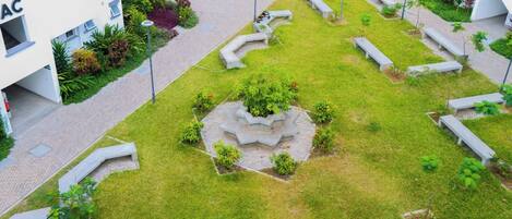 Un patio con jardín central, bancos y un sendero.