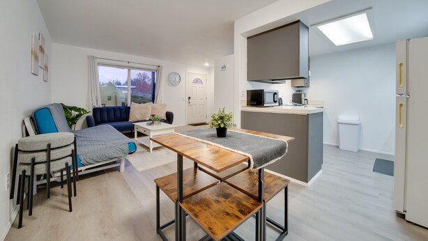 Un appartement moderne comprenant un coin repas, une cuisine et un salon.