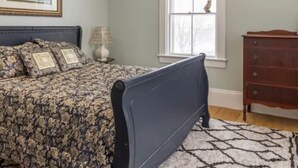 A bedroom with a bed, a dresser, a window with a view, and a painting on the wall. - Heart of Pubnico (Pubnico)