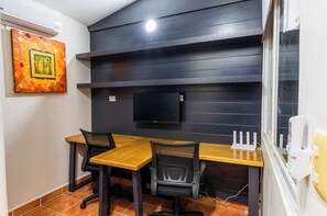 Work in comfort with a desk, two chairs, and a mounted TV.