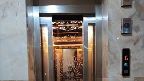 Een lift met een digitaal scherm waarop 'C' en een brandweerschakelaar staan.