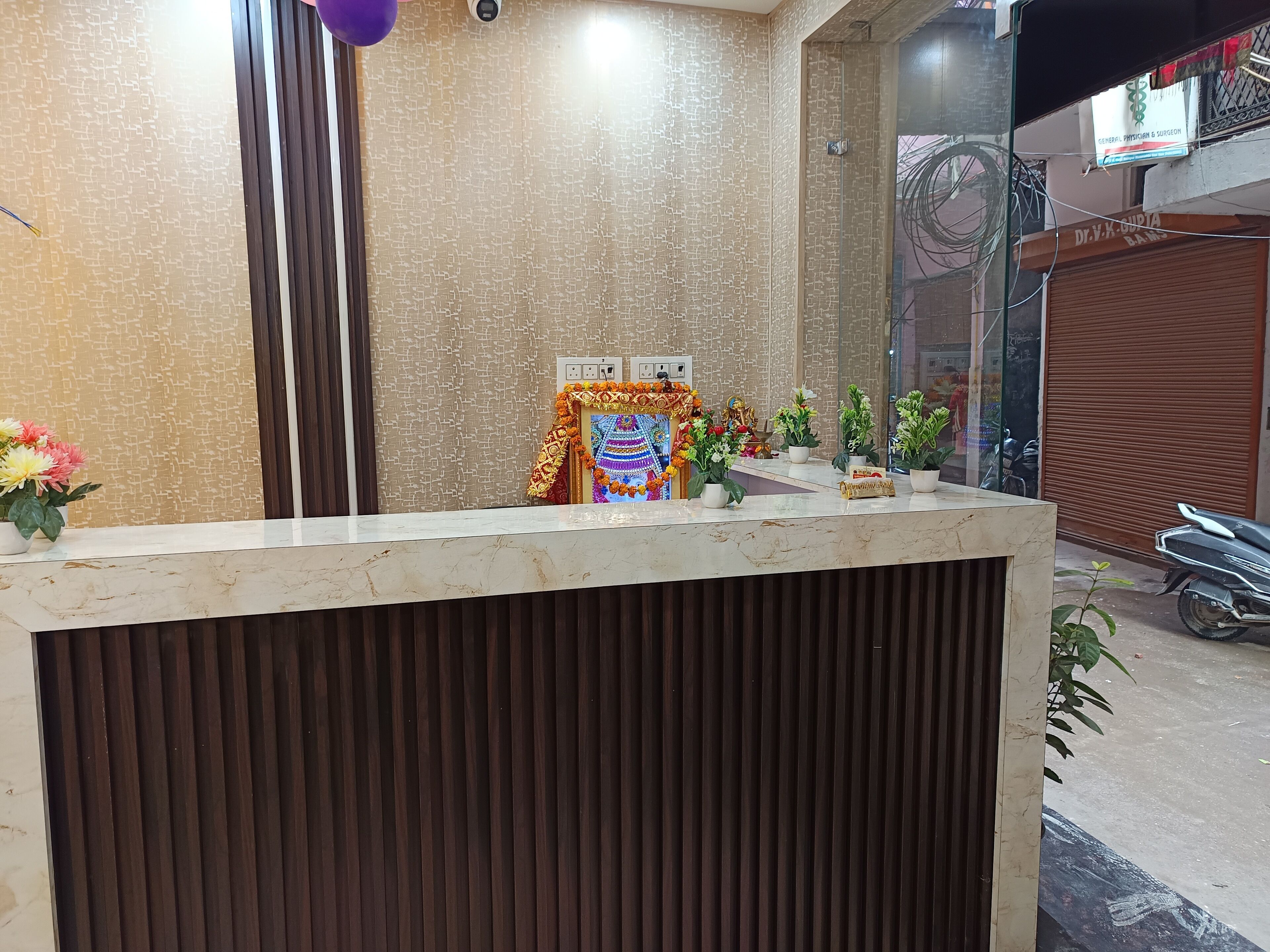 A reception desk with a patterned wall and a closed shutter door in the background.