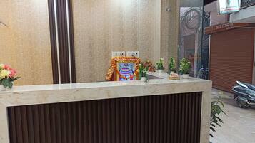 A reception desk with a patterned wall and a closed shutter door in the background.