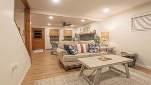 A cozy living room with a wooden floor, a sofa with patterned cushions, a coffee table, and a fireplace. - Charming Lake Front Home - Pet Friendly (Lake Norman of Catawba)