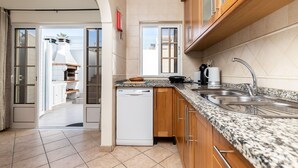 A modern kitchen with granite countertops, wooden cabinets, and a dishwasher.