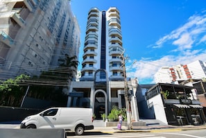 Un edificio de varios pisos con una entrada central y balcones.