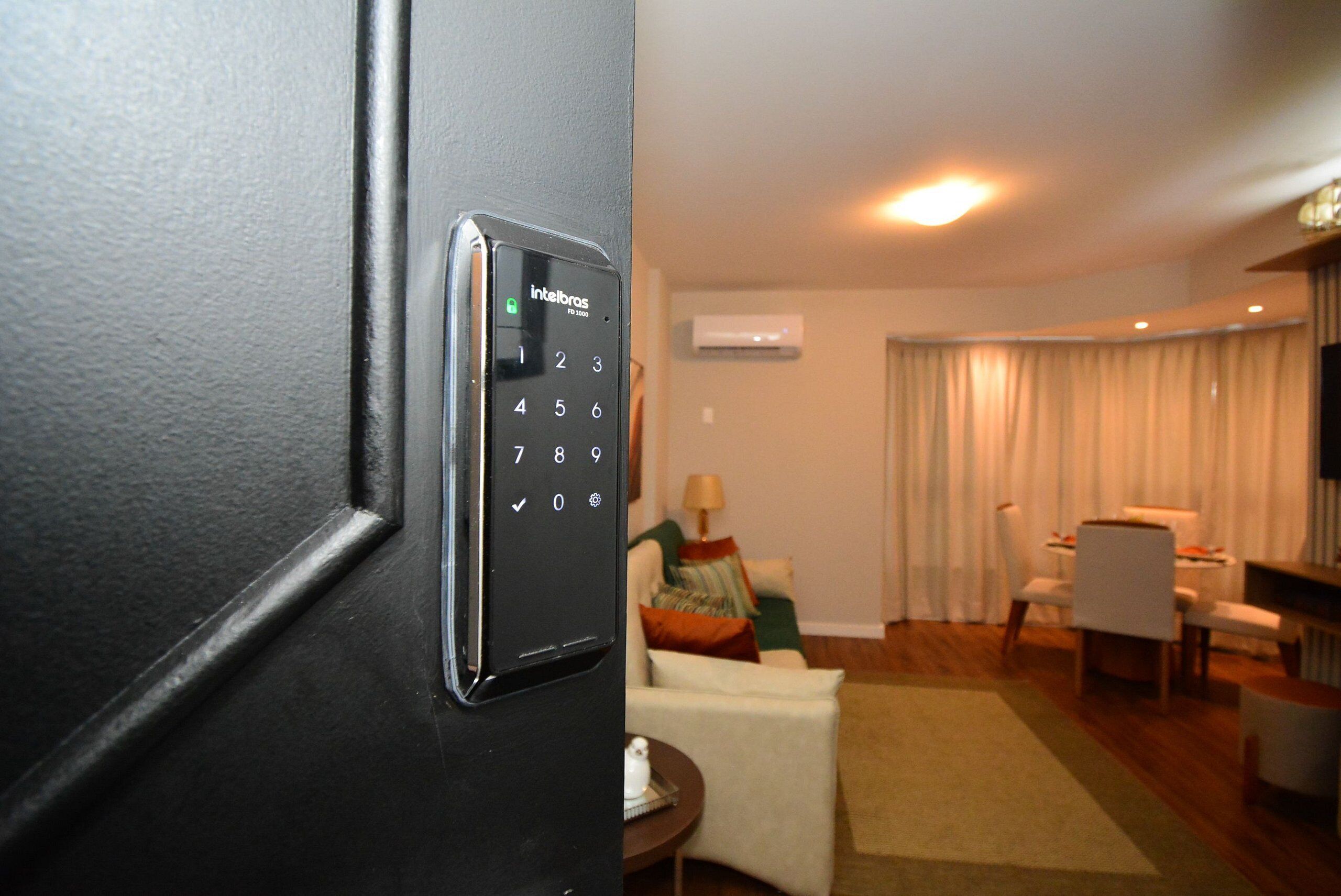 A modern hotel room with a digital door lock, a living area with a sofa, a coffee table, and a TV.