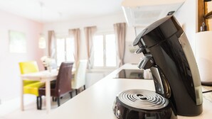 Una cocina moderna con una cafetera y una encimera blanca.