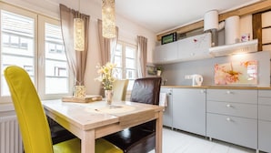 Una cocina moderna con una mesa de madera, sillas y un horno empotrado.