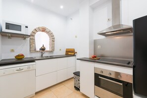 A modern kitchen with a microwave, oven, and stainless steel range hood.