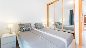 Un dormitorio moderno con una cama grande, dos mesitas de noche y un espejo.