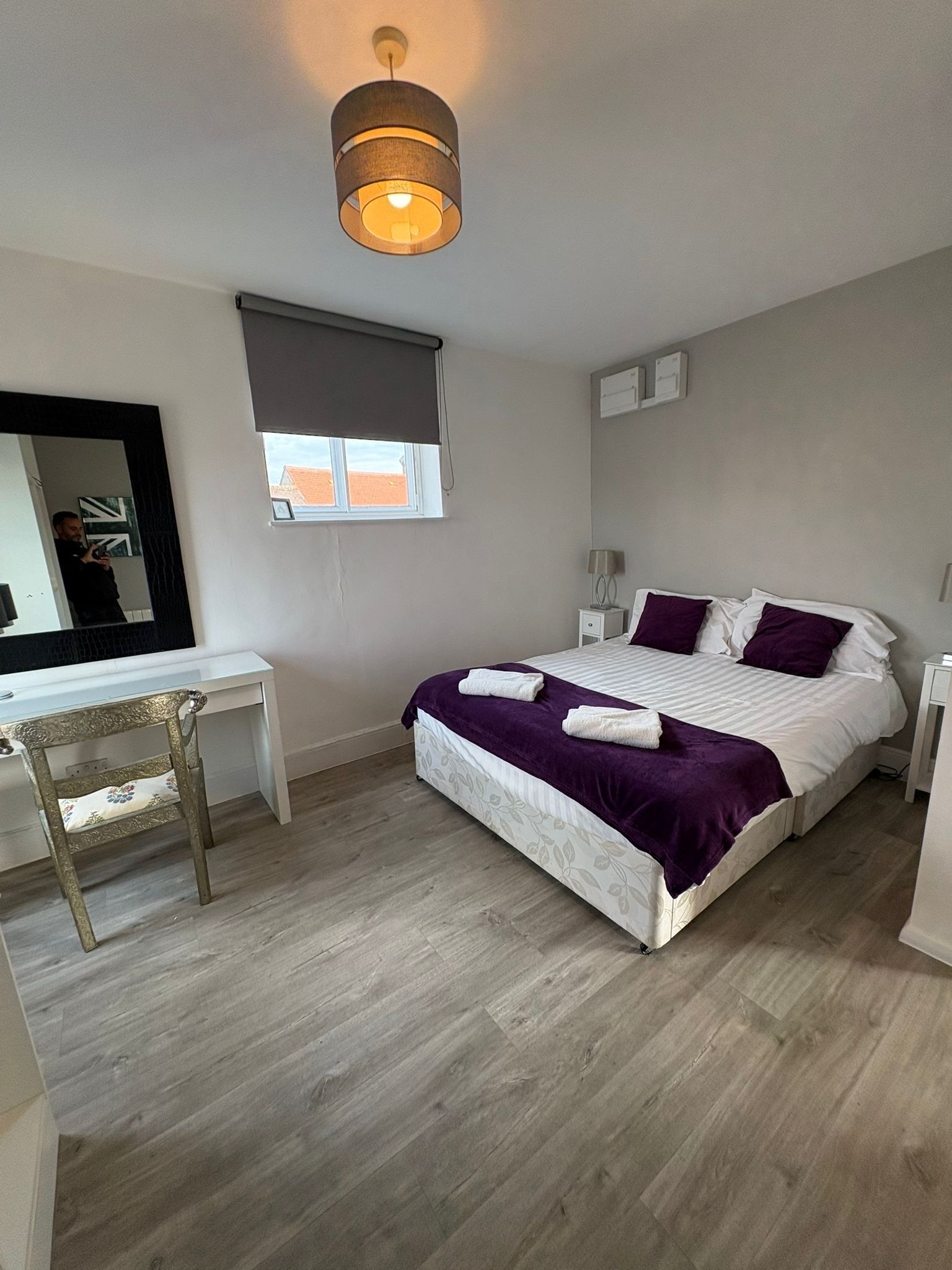 A bedroom with a bed, a desk, and a chair.