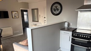 Een moderne keuken met een kookplaat, oven en witte kasten.