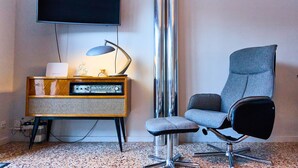 A modern room with a flat-screen TV, a vintage radio, a tall metallic column, and a contemporary office chair. - 𓃹 Bohemian Escape: Terrace, Parking by Ski Resort (Ordino)