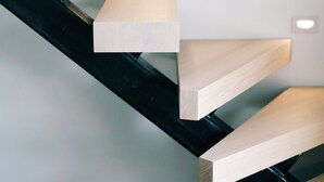 Una escalera moderna con escalones de madera e iluminación integrada.