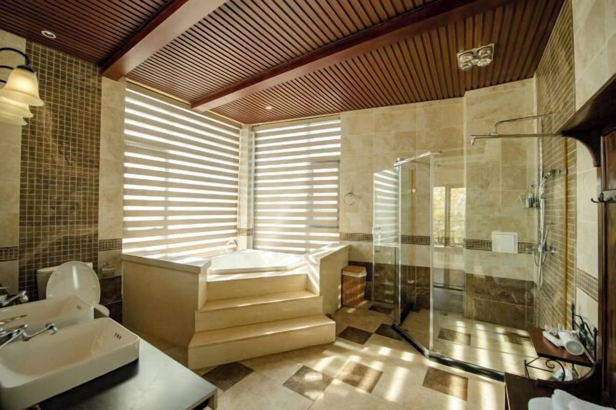 A modern bathroom with a bathtub, shower, and sink.