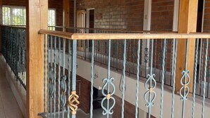 A covered outdoor area with a wooden ceiling, brick walls, and a metal railing with decorative elements. - 2-story country farm in Guarne (Guarne)