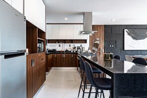 Enjoy cooking in this well-lit kitchen with a central island and bar stools.