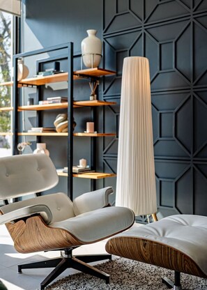 Contemporary space with a sleek chair, geometric-patterned wall, and floor lamp.
