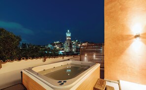 Un jacuzzi con vista a un paisaje urbano de noche.