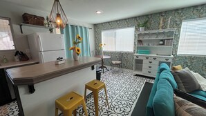 A compact kitchen with a central island, a dining area with a table and chairs, and a sofa in a living area. - Single bedroom in a charming house in fabulous Phoenix with WiFi, AC, & more! (Phoenix)