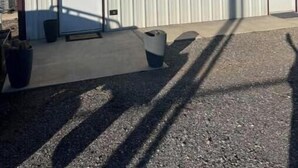 A large industrial building with a corrugated metal exterior, a door, and a small sign with a diamond symbol. - Hidden gem (Blanchard)