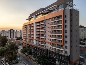 A multi-story residential building with balconies, a parking garage below, and a clear view of the surrounding cityscape. - AD330 (São Paulo)