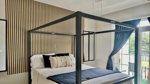 A four-poster bed with a headboard, a window with curtains, and a wall with vertical wooden slats. - Prime Location In Lewes-  3bed/2bath Great space and game room. (Lewes)