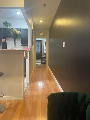 Stylish hallway leads to a well-equipped kitchen with a sink and countertop.