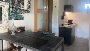 Een moderne keuken met een ingebouwde kookplaat, een spoelbak en een aanrecht. Er is een houten deur die naar een andere kamer leidt.