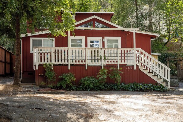A red building with a white balcony and a staircase leading to the entrance. - Riverbend Retreat - Hot Tub and Tastings Included (Healdsburg)
