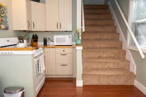 A kitchen with wooden cabinets, a microwave, and a stove.