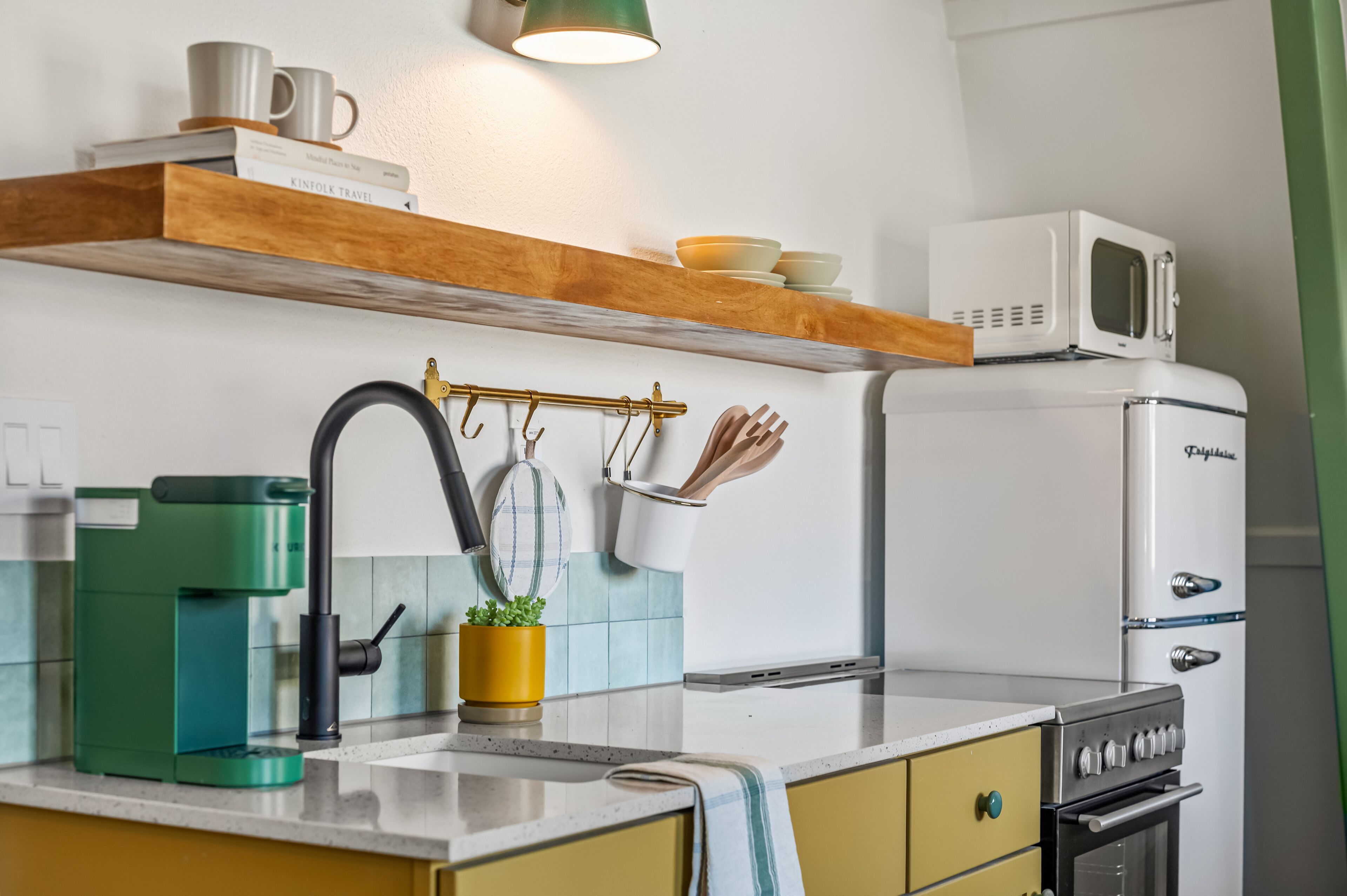 A kitchen with a coffee maker, microwave, and stove.