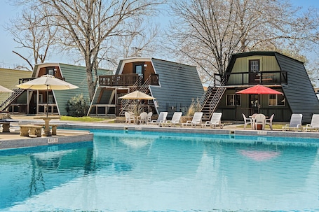 Una piscina al aire libre de temporada, sillones reclinables de piscina