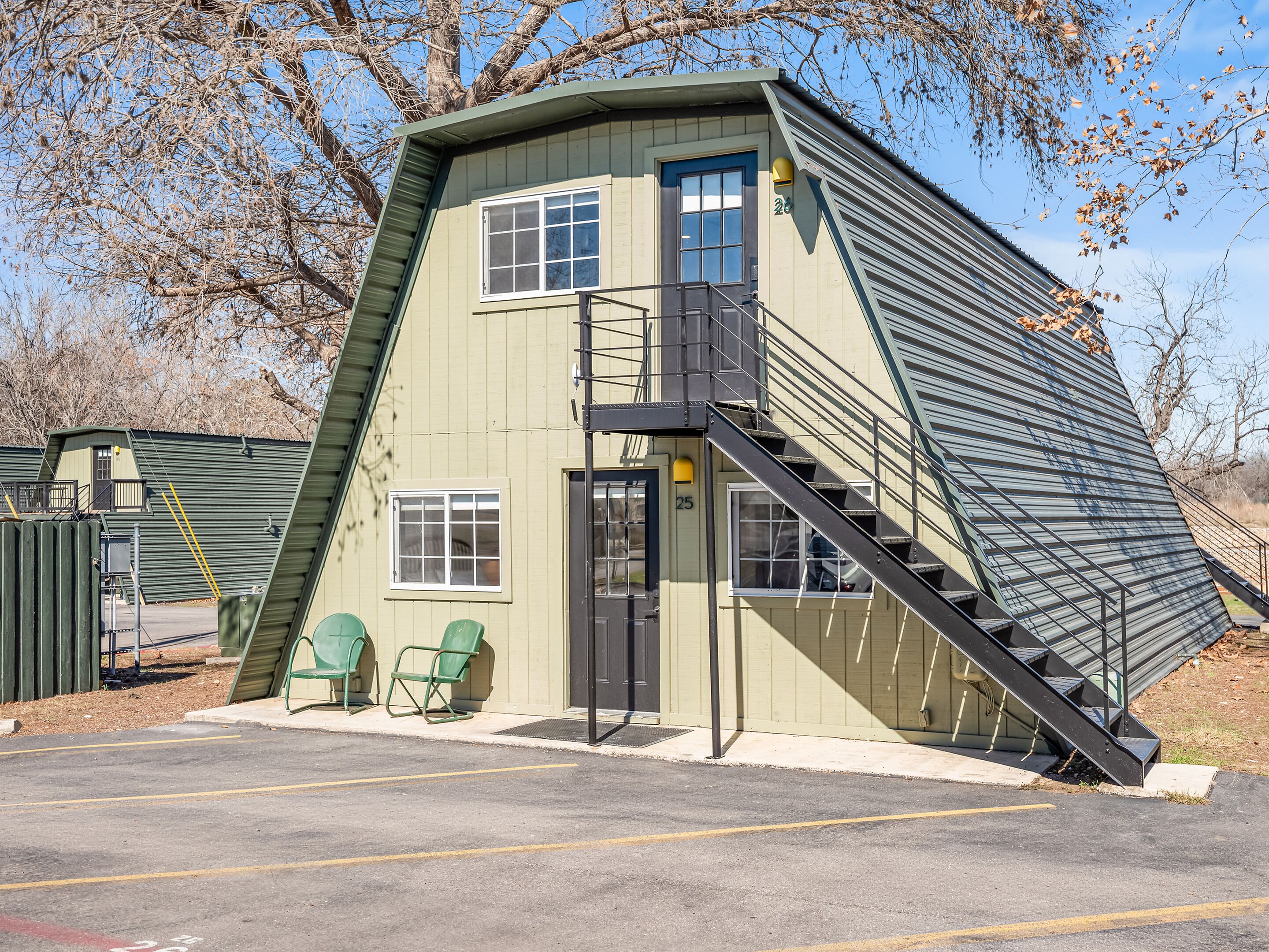 A building with a slanted roof, a staircase, and a door.