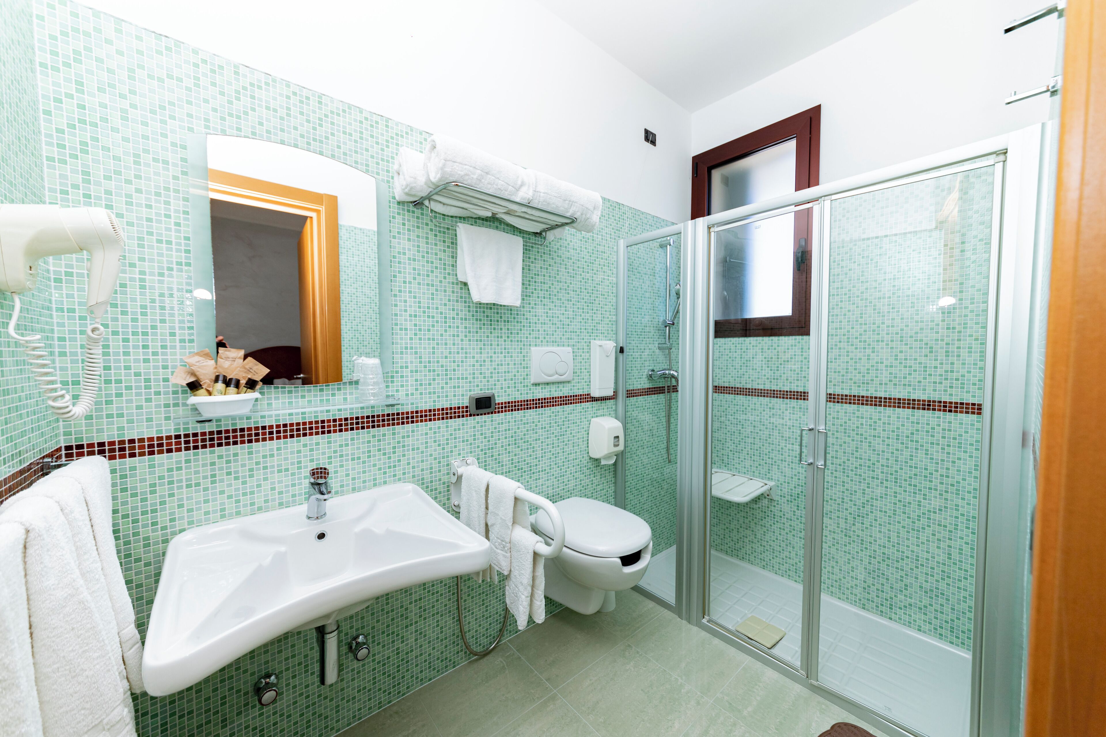 A bathroom with a sink, toilet, and glass shower enclosure.