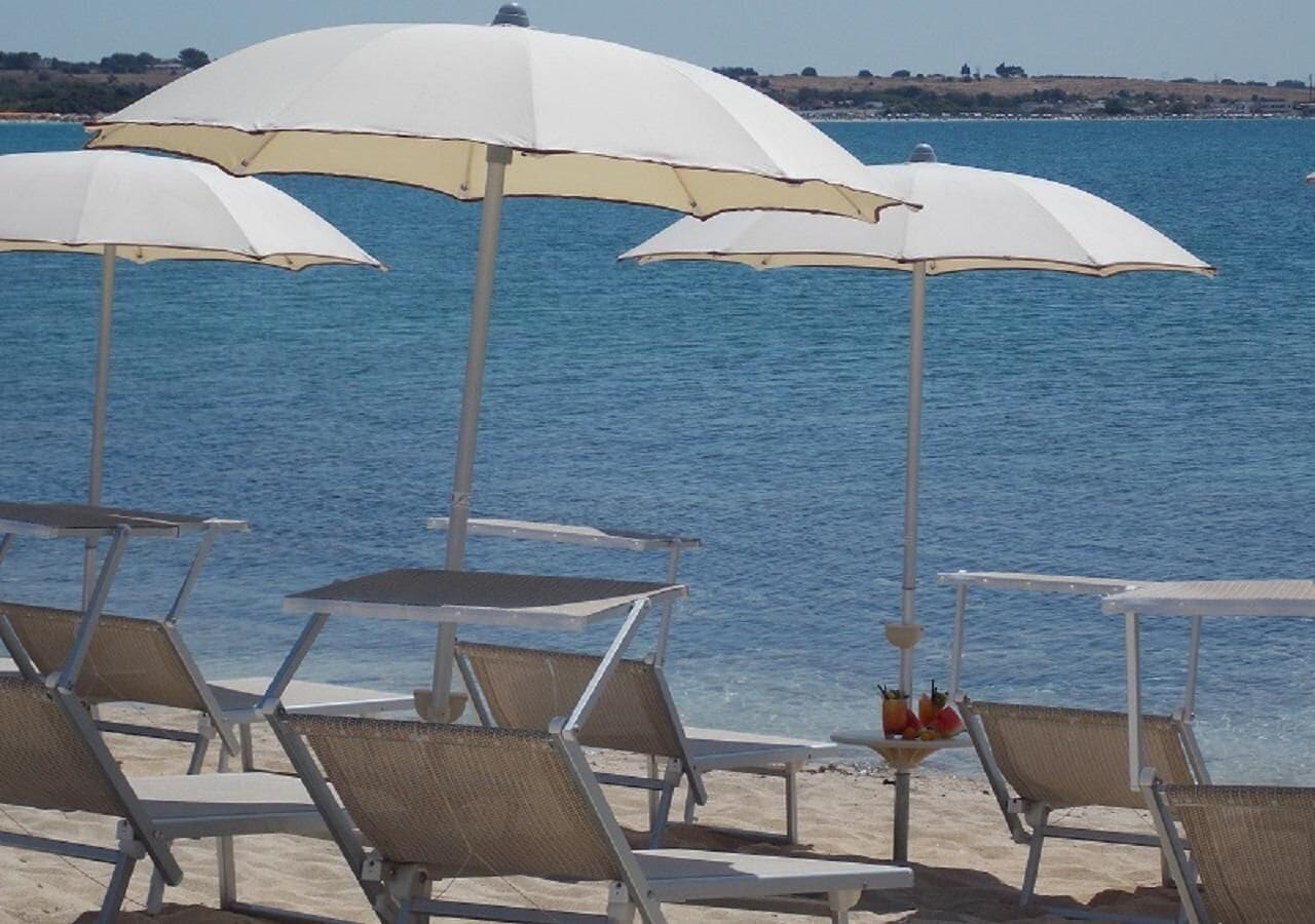 Un espace aménagé au bord de la plage, avec des parasols et des chaises longues.