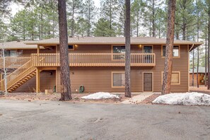 A two-story cabin with a wooden balcony, a staircase, and a door. - Sledding Thrills & Fireside Warmth: Pinetop Home (Pinetop)