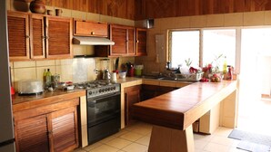 A kitchen with wooden cabinets, a stove, and a large island. - Room-your Best Hideaway in the Coolest n (Zapopan)