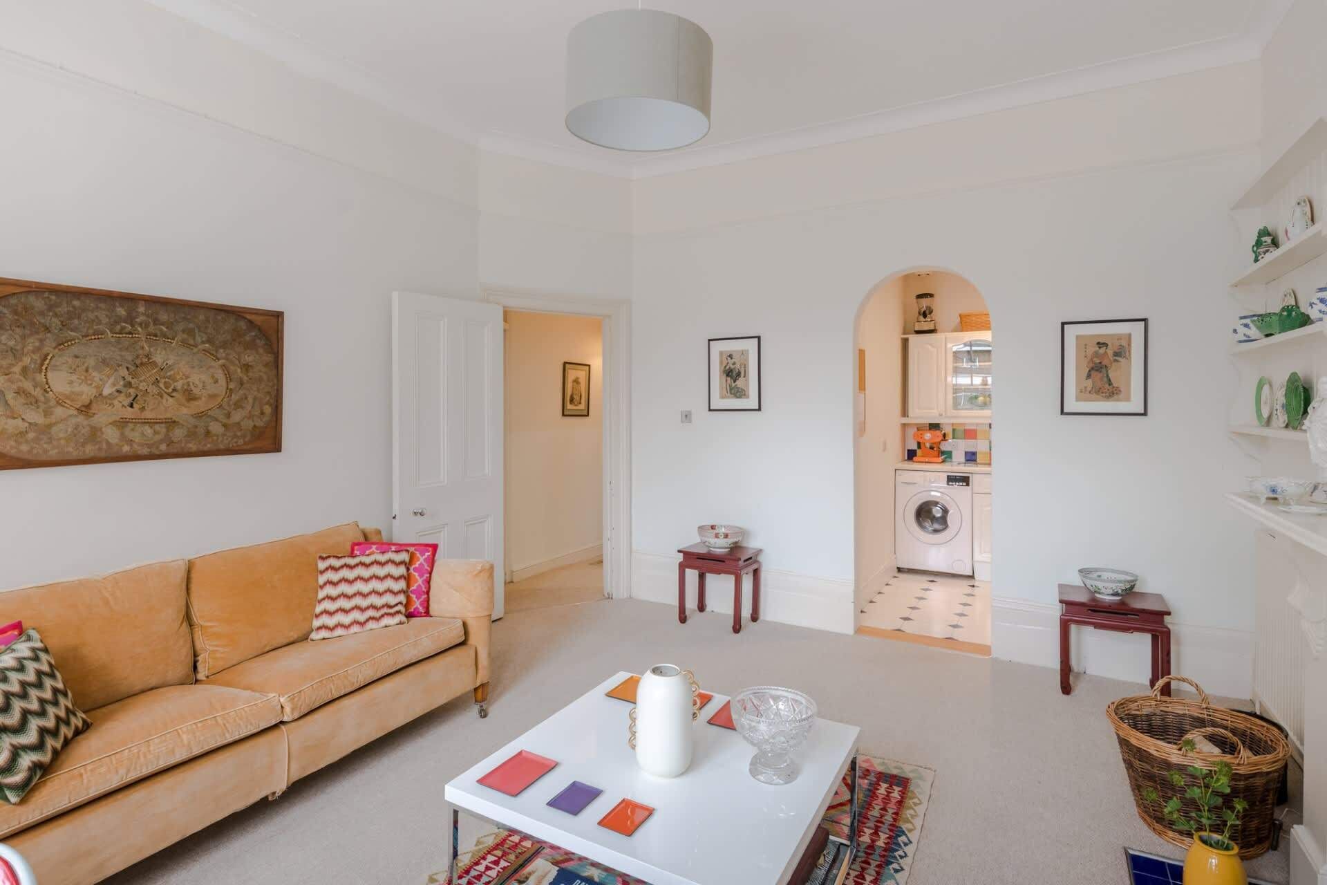 A living room with a sofa, coffee table, and a view into the kitchen.